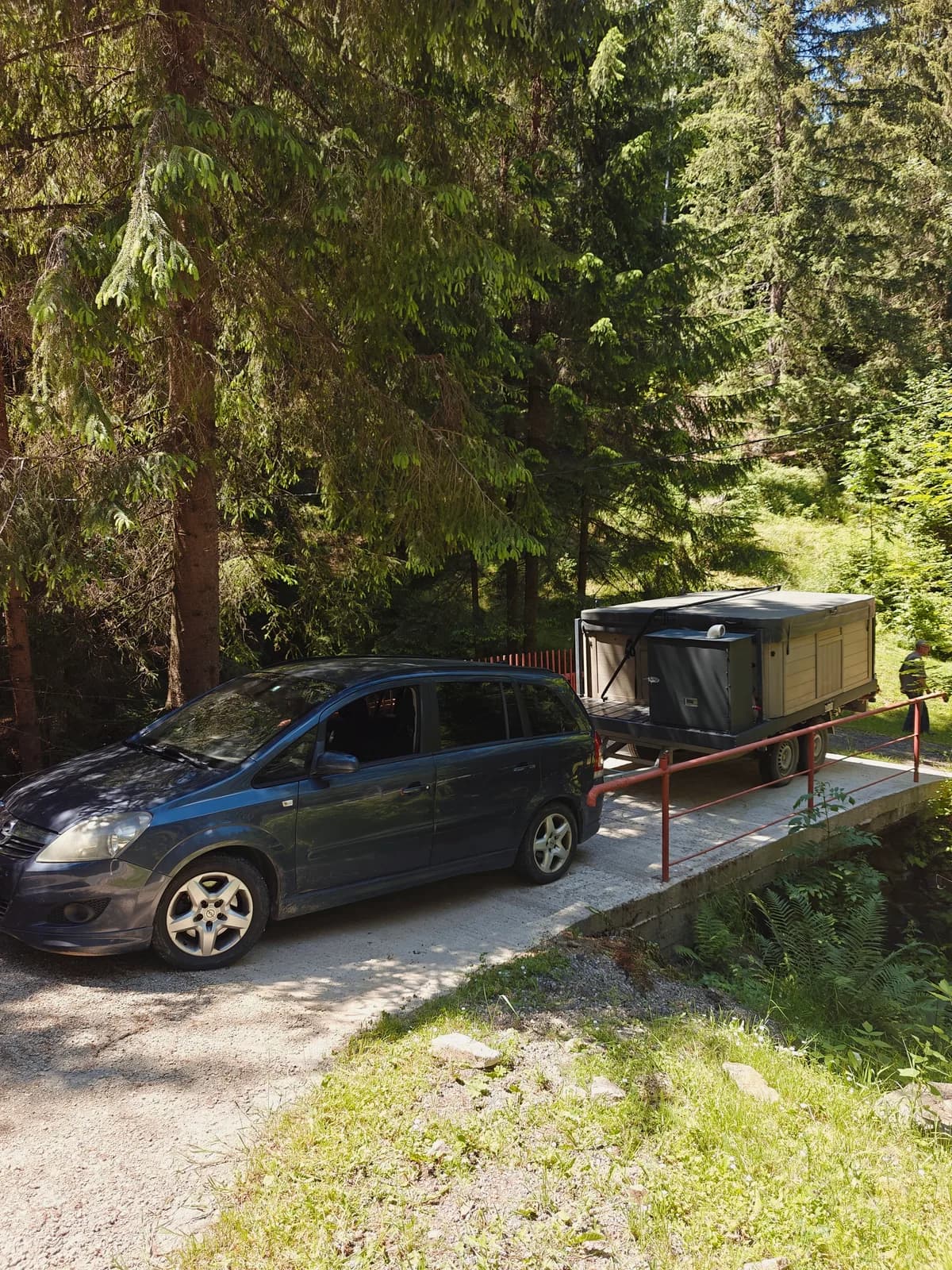 Mașină tractând remorca cu jacuzzi-ul APUS peste un pod, pe un drum forestier din Munții Apuseni
