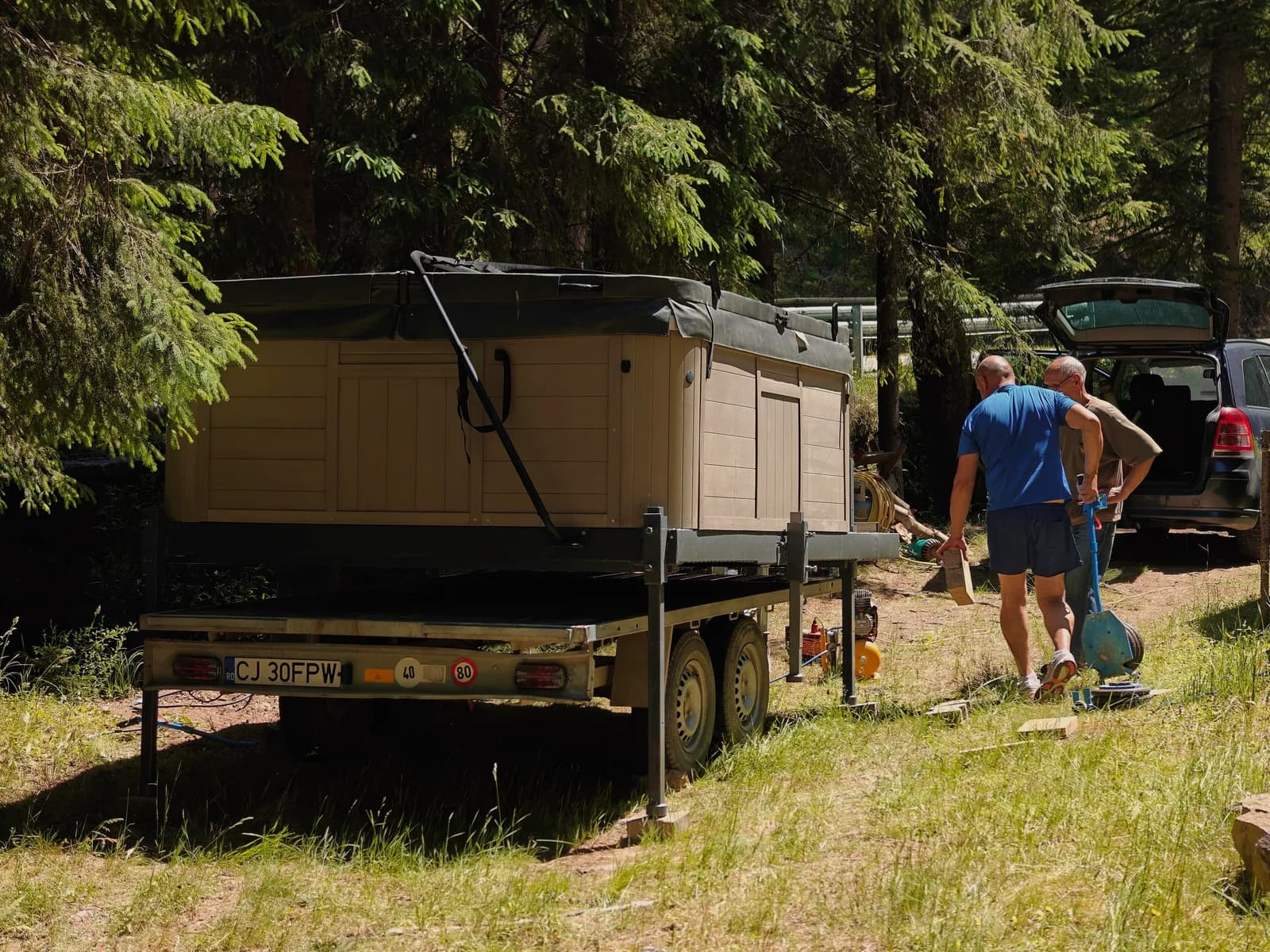 Echipa APUS instalând jacuzzi-ul într-o poiană însorită, lângă pădure